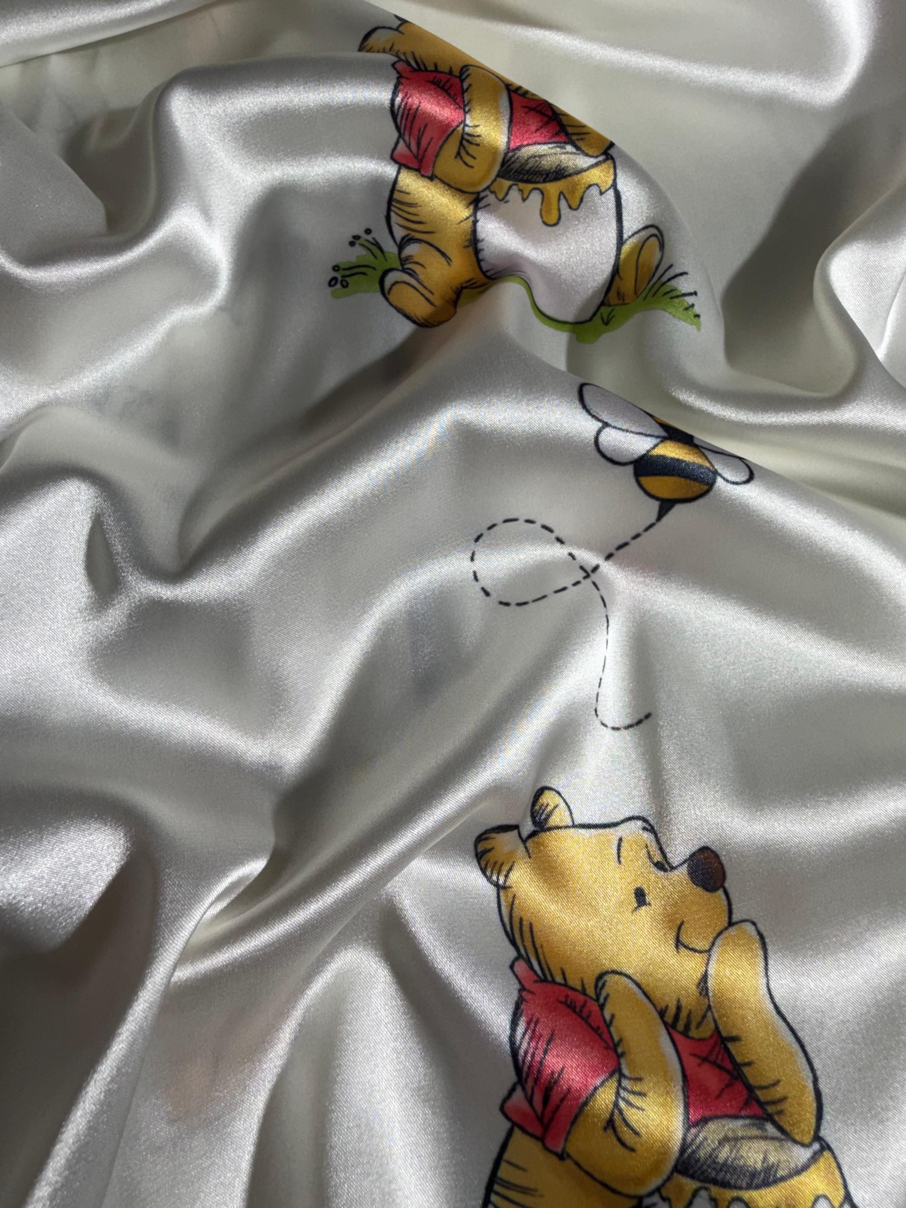 Detalle de tela suave de pijama Winnie Pooh con estampado del personaje